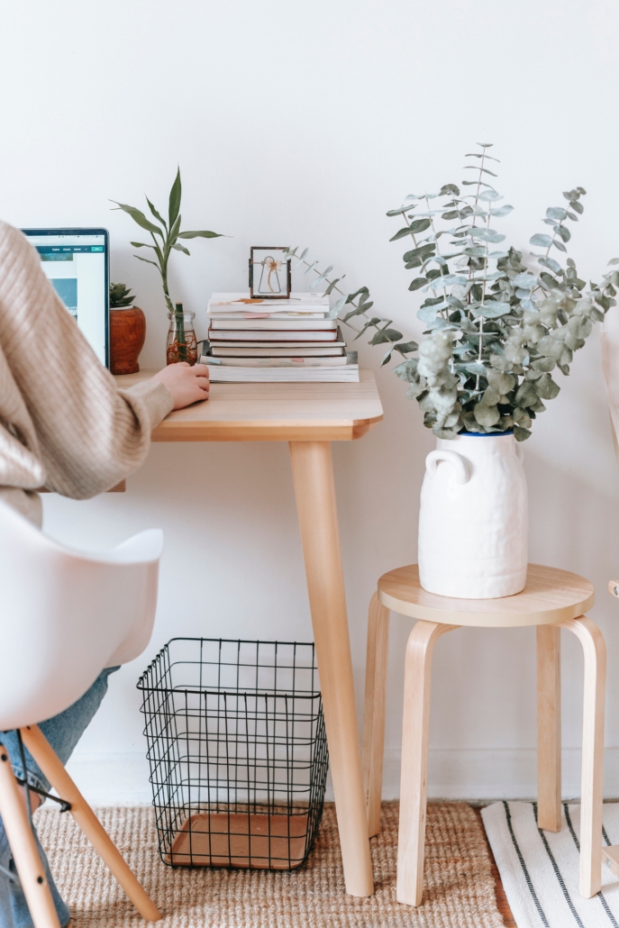 Cozy workspace with plants and stacked books.